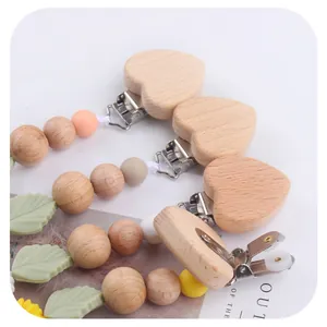 Baby pacifier clips with beech wood heart and colorful silicone beads on white background