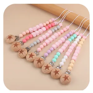 Detail of pink silicone pacifier clips with beech wood stars and baby letter beads