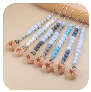 Detail of baby pacifier clips with silicone beads and star-patterned beech wood clips