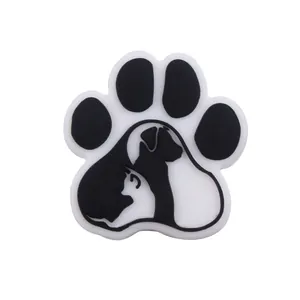 Close-up of black and white paw print silicone bead with cat and dog silhouettes for DIY crafts