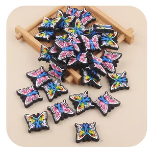 Detailed macro view of colorful butterfly PVC charms for clogs with blue ribbon symbol