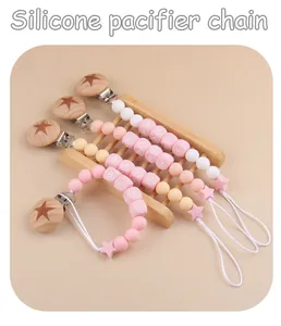 Detail of pink silicone pacifier clips with beech wood stars and baby letter beads