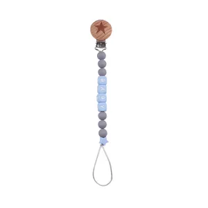 Detail of baby pacifier clip with beech wood clip, silicone beads, and star accent