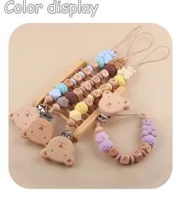 Detail eines Bären-Schnullerketten-Sets aus Holz mit Silikonperlen und BABY-Lettern