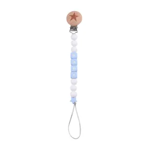 Close-up of wooden star clip and blue baby beads for pacifier chain DIY