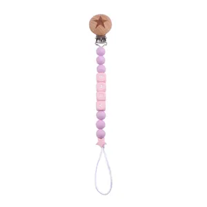 Macro detail of silicone pacifier chain with pink BABY letter beads and star accents