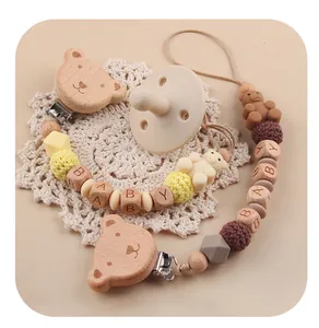 Detail eines Baby-Schnullersets mit Holzbären-Clip, Silikonperlen und BABY-Gravur