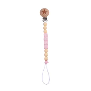 Detail of pink silicone beads and wooden star clip on a customized baby pacifier chain