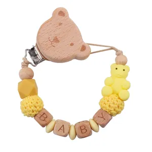 Detail der Baby-Schnullerkette mit Holzbären-Clip, gelben Häkelperlen und BABY-Buchstabenperlen