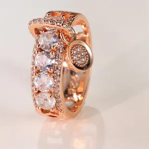 Vue macro d'une bague S925 en or rose avec zircons incrustés et un pendentif scintillant