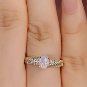 Detailed close-up of a luxury oval opal ring with pavé diamond band in 18k gold finish