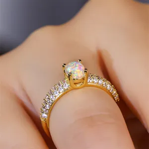 Close-up of luxury gold ring with oval opal stone and micro-paved zircon stones