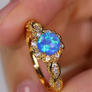 Makroaufnahme: Goldener Vintage-Ring mit blauem Opal und aufwendig geflochtener Ringschiene