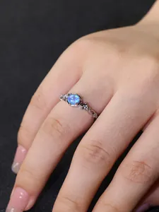 Detailansicht eines Vintage-Silberrings mit blauem Opal und Pavé-Besatz auf der Haut