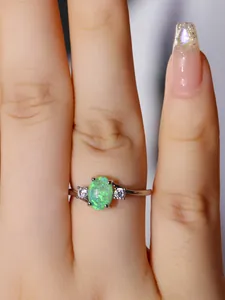 Dettaglio anello in argento con opale verde ovale e zirconi bianchi indossato al dito