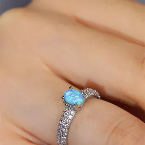 Elegant four-claw oval blue opal ring with triple row pavé zircon setting on silver band