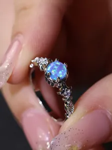 Makroaufnahme eines Silberrings mit sechszackigem blauem Opal und Vintage-Blumendetails