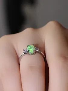 Vista macro dell'anello d'argento con opale verde ovale e zirconi laterali