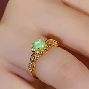 Nahaufnahme eines Vintage-Ringes mit grünem Opal und floralem Goldspitzenmuster