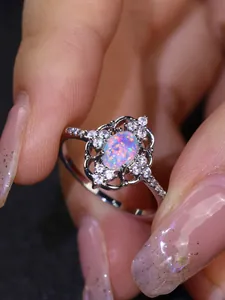 Detalle de anillo de plata vintage con ópalo ovalado y diseño de encaje calado