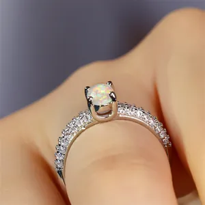 Macro shot of oval opal ring with zircon side stones and polished silver band