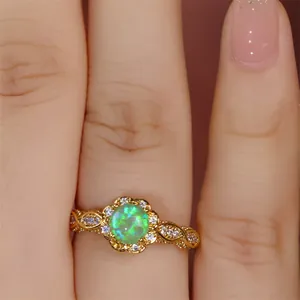 Makroaufnahme von Vintage-Goldring mit grünem Opal und filigranem, offenem Spitzendesign