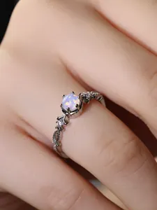 Makroaufnahme eines Vintage-Opal-Rings mit gedrehtem Band und Zirkonia-Akzenten