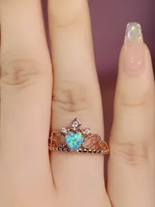 Close-up of rose gold crown ring featuring a heart-shaped opal and zircon accents