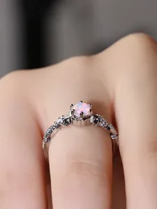 Nahaufnahme eines silbernen Opalrings mit Sechs-Krallen-Fassung an der Hand