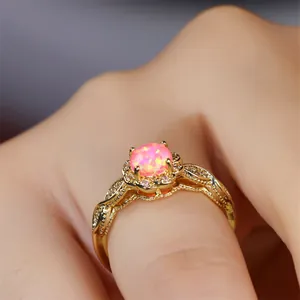 Nahaufnahme eines goldenen Vintage-Blumenrings mit rosa Opal und funkelnden Steinen