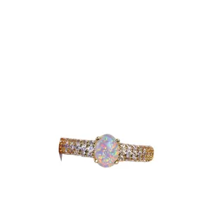 Luxurious gold ring featuring an oval opal centerpiece with pavé-set round zircon stones