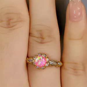 Makroaufnahme eines Vintage-Goldrings mit runder rosa Opal-Blume und Spitzenmuster