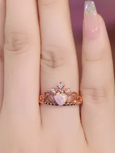 Close-up of rose gold crown ring featuring a heart-shaped opal stone and small crystals