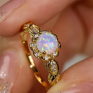 Makroaufnahme von Vintage-Goldring mit weißem Opal und Diamant-Spitzenverzierung
