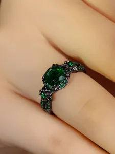Macro shot of vintage black plated ring with large oval green stone and floral details