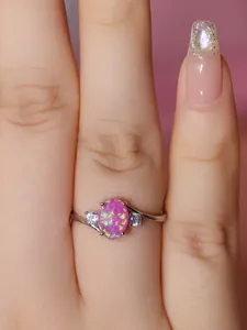 Macro di anello in argento con opale rosa ovale e zirconi sulle dita