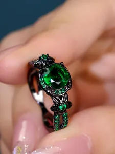 Macro detail of vintage black metal ring featuring a large round green zircon center stone