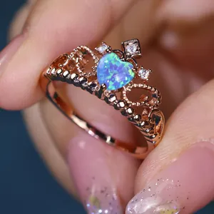 Elegant rose gold crown ring featuring a heart-shaped blue opal and sparkling zircon accents