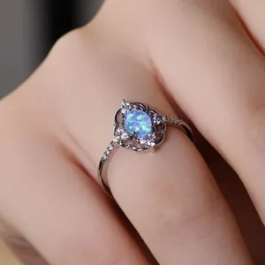Elegante anillo de plata con opalo azul ovalado y patron de flores huecas vintage