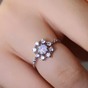 Elegante anello con opale e zirconi bianchi indossato su una mano di una donna