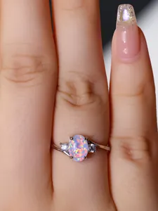 Dettaglio dell'anello in argento con opale ovale e diamanti bianchi su un modello