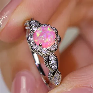 Makroansicht des rosa Opalrings mit floraler Spitze aus Silber und funkelnden Steinen