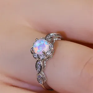 Makroaufnahme des Vintage-Opalrings mit filigranem Spitzenband und glänzenden Edelsteinen