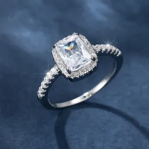 Macro shot of rectangular halo ring with sparkling main stone and pave diamond band