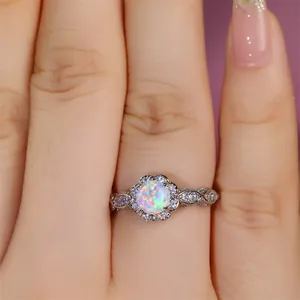 Makroaufnahme eines Vintage-Ringes mit weißem Opal, Blumenmuster und kleinen Diamanten