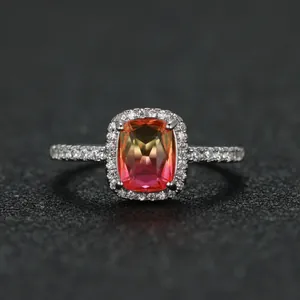 Macro detail of rectangle bicolour sunset gem ring with white pavé diamond halo
