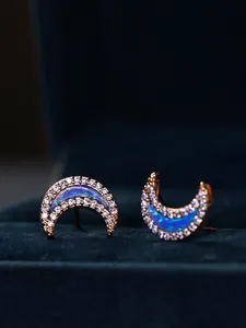 Macro detail of crescent moon earrings in rose gold finish with opal and crystals