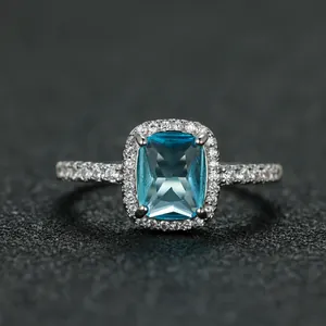Macro detail of platinum rectangular blue gemstone ring with pave cubic zirconia accents