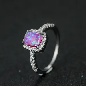 Vista macro dell'anello con opale rosa-viola rettangolare e halo di piccoli diamanti