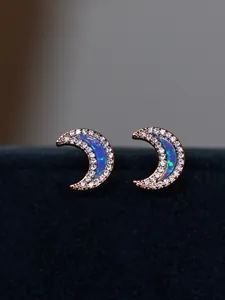 Macro shot of rose gold crescent moon earrings with opal inlay and sparkling zircons